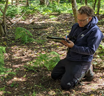 Surveyor kneeling down with clipboard